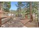 Wooden deck overlooking a wooded landscape, equipped with outdoor seating and a bird feeder at 13495 Shiloh Rd, Conifer, CO 80433