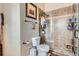 Tiled bathroom with a glass enclosed shower, a decorative tiled accent border, and a classic white toilet at 13495 Shiloh Rd, Conifer, CO 80433