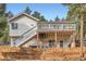 Back exterior view of this home with two levels of decks, and mature trees on the property at 13495 Shiloh Rd, Conifer, CO 80433