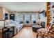 Spacious living room with plush sectional, fireplace, and large windows offering natural light at 13495 Shiloh Rd, Conifer, CO 80433
