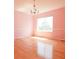 Cozy bedroom featuring hardwood floors, a large window, and a chandelier for soft lighting at 18112 E Dorado Ave, Centennial, CO 80015