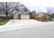 Two-story home with three-car garage, brick accents, and manicured lawn at 18112 E Dorado Ave, Centennial, CO 80015