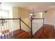 Open hallway with hardwood floors, chandelier lighting, and staircase to lower level at 18112 E Dorado Ave, Centennial, CO 80015