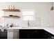 Close-up of a bright kitchen featuring open shelving, quartz countertops, and dark cabinets at 171 S Pennsylvania St, Denver, CO 80209