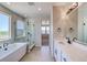 Modern bathroom with a soaking tub, glass shower, and dual sinks with stone countertops at 680 Tubman Dr, Elizabeth, CO 80107