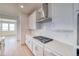 Well-equipped kitchen with white cabinets, quartz countertops, stainless steel hood, and gas range at 680 Tubman Dr, Elizabeth, CO 80107