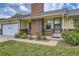 Charming home with a brick chimney and lush green lawn and walkway to the front door at 1431 S Chambers Cir, Aurora, CO 80012