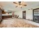 Spacious living room with tile flooring and a ceiling fan, leading to the kitchen area at 1431 S Chambers Cir, Aurora, CO 80012