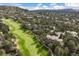 Stunning aerial view of a golf course community surrounded by mature trees and lush landscaping on a sunny day at 145 Capulin Pl, Castle Rock, CO 80108