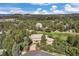 Aerial view of a luxurious home nestled in a wooded area near a golf course with mountain views at 145 Capulin Pl, Castle Rock, CO 80108