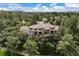 Aerial view of a grand home surrounded by lush greenery and mature trees at 145 Capulin Pl, Castle Rock, CO 80108