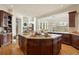 Large kitchen island features granite counters, cooktop, cabinets and hardwood floors in this spacious room at 145 Capulin Pl, Castle Rock, CO 80108