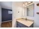 Bathroom featuring stylish vanity with marble countertop and modern fixtures, next to bedroom at 5669 Johnson Ct, Arvada, CO 80002