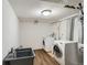 A laundry room with modern washer and dryer units, a utility sink, and wood-look flooring at 5669 Johnson Ct, Arvada, CO 80002