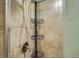 Close-up of a shower with tiled walls, metal fixtures, and corner storage at 5669 Johnson Ct, Arvada, CO 80002