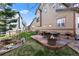 Backyard patio featuring a dining set and a fire pit, all surrounded by lush greenery at 4236 Frederick Cir, Longmont, CO 80503