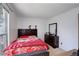 Bedroom with a red bedspread, dark wood furniture, and a window at 1123 S Biscay St, Aurora, CO 80017