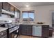 Kitchen with black cabinetry, stainless steel appliances, and a window at 1123 S Biscay St, Aurora, CO 80017