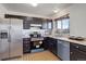 Kitchen with black cabinetry, stainless steel appliances, and a window at 1123 S Biscay St, Aurora, CO 80017