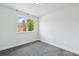 Bedroom with neutral walls, gray carpet, and window overlooking an adjacent home and tree at 1203 S Zeno Way # B, Aurora, CO 80017