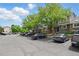 Parking area with mature trees in front of multi-Gathering units at 1203 S Zeno Way # B, Aurora, CO 80017