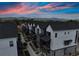Aerial view showcases modern townhomes with sunset, offering a glimpse of community and mountain views at 5189 Vivian St, Wheat Ridge, CO 80033