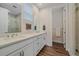 Modern bathroom with double sinks, a glass-enclosed shower, and wood flooring at 5189 Vivian St, Wheat Ridge, CO 80033