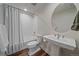 Well-lit bathroom featuring a shower-tub combo, pedestal sink, and modern fixtures for a clean aesthetic at 5189 Vivian St, Wheat Ridge, CO 80033