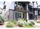 Modern townhome featuring a brick facade, a balcony with seating, and professionally landscaped surroundings at 5189 Vivian St, Wheat Ridge, CO 80033