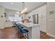 Modern kitchen with white cabinets, stainless steel appliances, and a large island with seating at 5189 Vivian St, Wheat Ridge, CO 80033