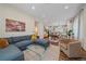 Open-concept living room boasts a large sectional sofa, glass coffee table, and hardwood floors at 5189 Vivian St, Wheat Ridge, CO 80033