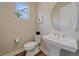 Stylish powder room featuring modern fixtures, a pedestal sink, and natural light at 5189 Vivian St, Wheat Ridge, CO 80033