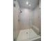 A frameless glass shower with a bench, rain shower head and elegant tile at 5189 Vivian St, Wheat Ridge, CO 80033