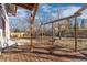 Backyard deck with wooden beams, providing a shaded outdoor living space with views of the surrounding trees and sky at 11970 W Pleasant Ave, Lakewood, CO 80401