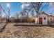 Backyard featuring a play area, a storage shed, and mature trees providing shade, perfect for outdoor activities at 11970 W Pleasant Ave, Lakewood, CO 80401