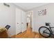 Hallway with hardwood flooring, neutral walls, and a peek into a connected space with a bike stored indoors at 11970 W Pleasant Ave, Lakewood, CO 80401