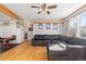 Open-concept living room and dining area with hardwood floors, a gray sectional couch, and natural light at 11970 W Pleasant Ave, Lakewood, CO 80401