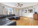 Cozy living room with hardwood floors, a comfortable sofa, and natural light from multiple windows at 11970 W Pleasant Ave, Lakewood, CO 80401