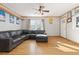 Bright living room with hardwood floors, a comfy gray sectional couch and a ceiling fan at 11970 W Pleasant Ave, Lakewood, CO 80401