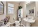 Powder room with pedestal sink, window, and decorative shelving at 13711 Ash Cir, Thornton, CO 80602