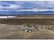 An aerial view of a ranch house near a lake with snow-capped mountains in the distance at 14798 N 115Th St, Longmont, CO 80504