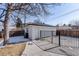 A detached garage with a gated entrance and a driveway, set against a partly snow-covered yard at 3180 S Albion St, Denver, CO 80222
