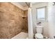 Cozy bathroom with tiled walls and bathtub, featuring a bright window for ample natural light at 3842 S Quebec St, Denver, CO 80237