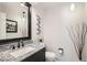 Stylish half bathroom with granite countertop, modern fixtures, and decorative wall accents at 3842 S Quebec St, Denver, CO 80237
