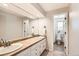 Bright bathroom featuring double sinks, a large mirror, and a separate toilet area at 3842 S Quebec St, Denver, CO 80237