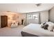Bright bedroom featuring a large bed, cozy seating area, and ample natural light at 3842 S Quebec St, Denver, CO 80237