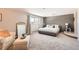 Spacious bedroom with plush carpet, statement wall, and comfortable seating area at 3842 S Quebec St, Denver, CO 80237