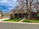 Charming brick home with a covered porch, lush lawn, and mature trees at 3842 S Quebec St, Denver, CO 80237