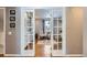 Bright office space with hardwood floors and a cozy chair seen through french doors at 3842 S Quebec St, Denver, CO 80237
