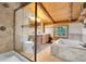Bathroom with a shower, tub, and double vanity beneath the wood-beam ceiling at 25704 Shiloh, Conifer, CO 80433